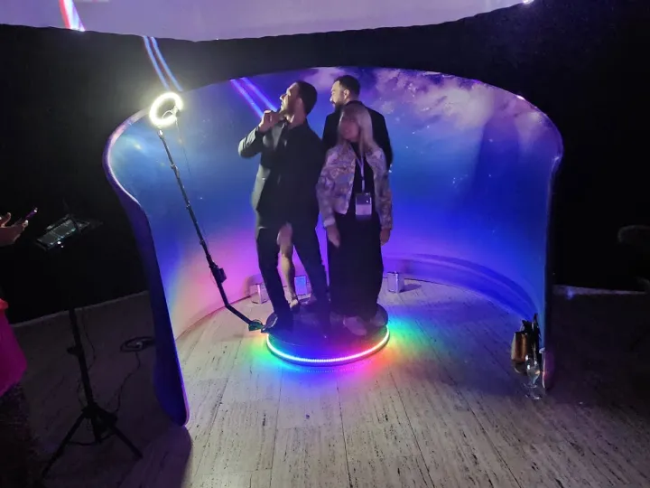 Invitados grabando un vídeo en la plataforma 360 con fondo curvo iluminado