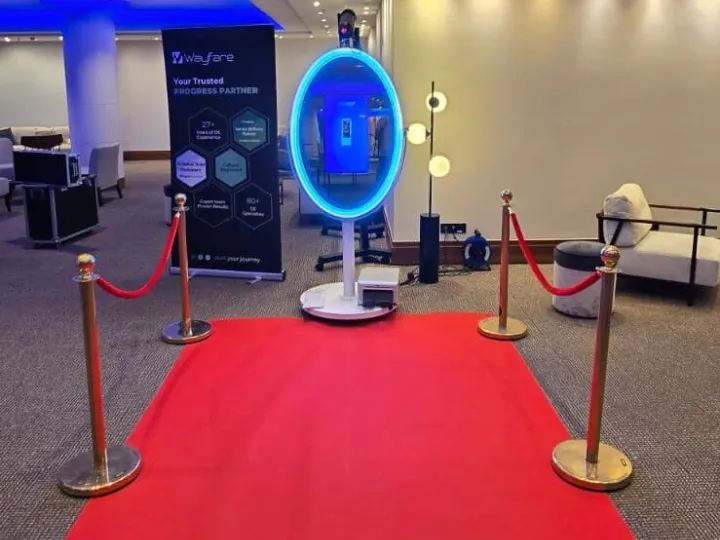Espejo mágico con alfombra roja y catenarias en la entrada de un evento
