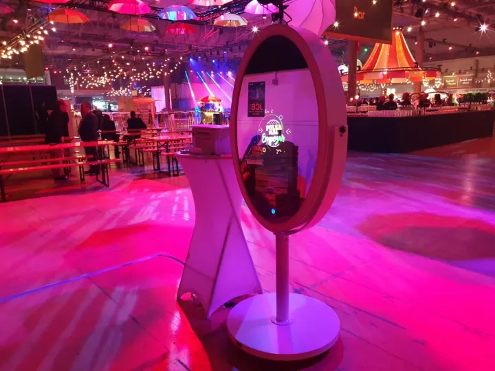 Fotomatón espejo mágico iluminado en una fiesta de empresa con luces rosas