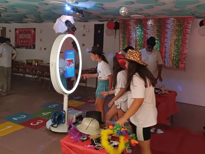Grupo de invitados con gafas y sombreros de atrezo ante el espejo mágico