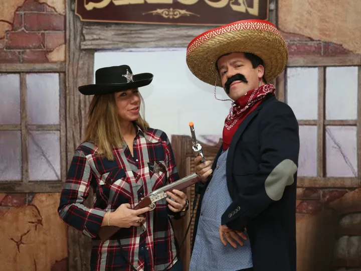 Invitados disfrazados de vaqueros ante un photocall del Far West