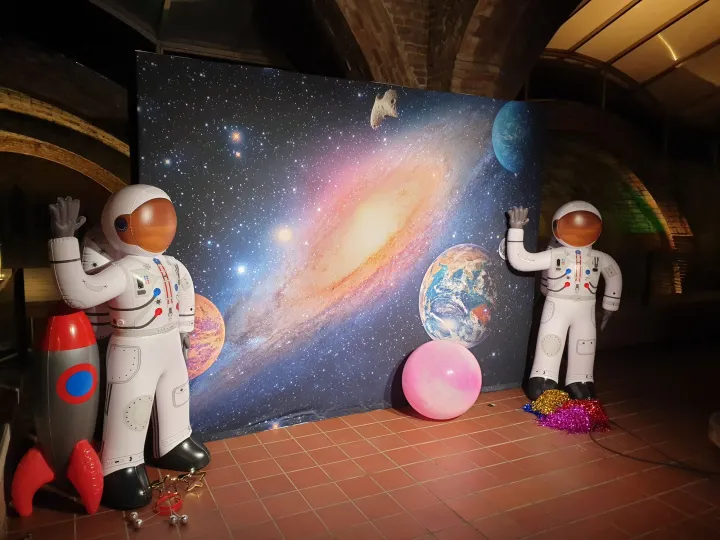 Space photocall with a galaxy backdrop and astronaut figures