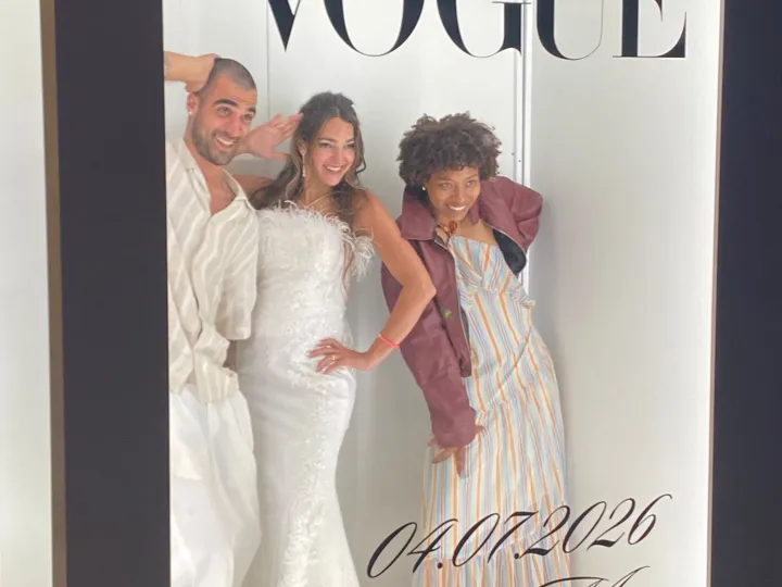 Tres invitadas posando dentro del photocall Vogue en una boda