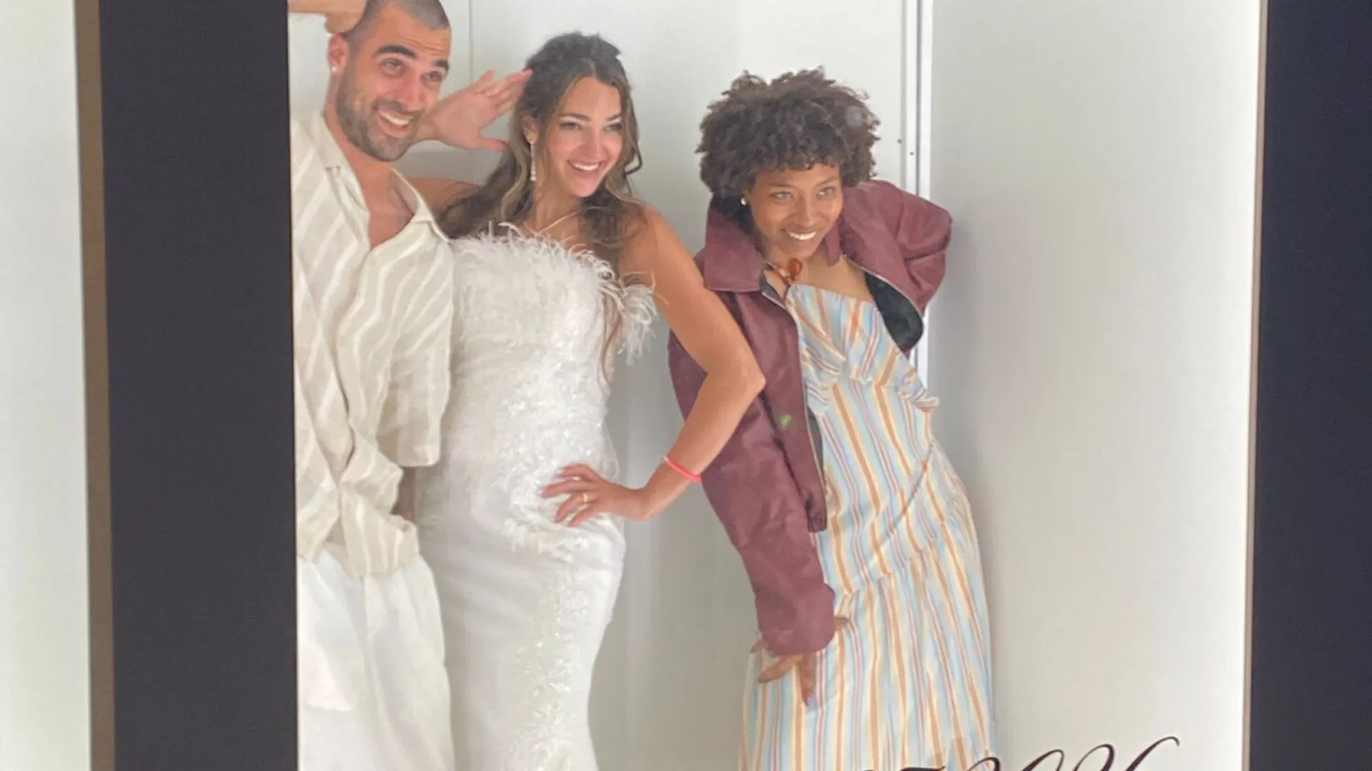 Tres invitadas posando dentro del photocall Vogue en una boda
