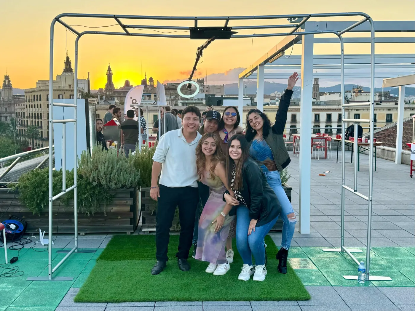 Grupo de invitados bajo el fotomatón 360 SKY en una terraza al atardecer