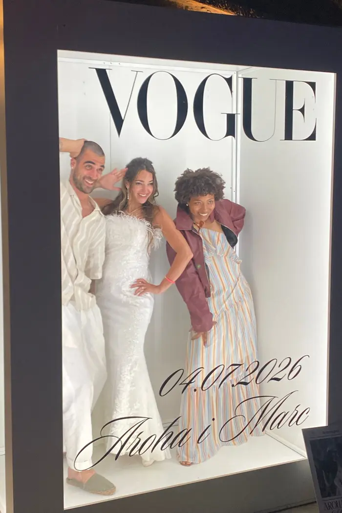 Tres invitadas posando dentro del photocall Vogue en una boda